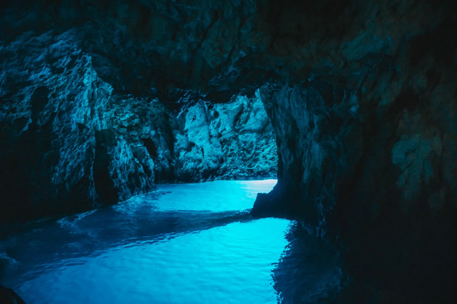 The Blue Cave chamber on Biševo, the whole pool glowing under dark rock (Blå Grottan – Privat tur)